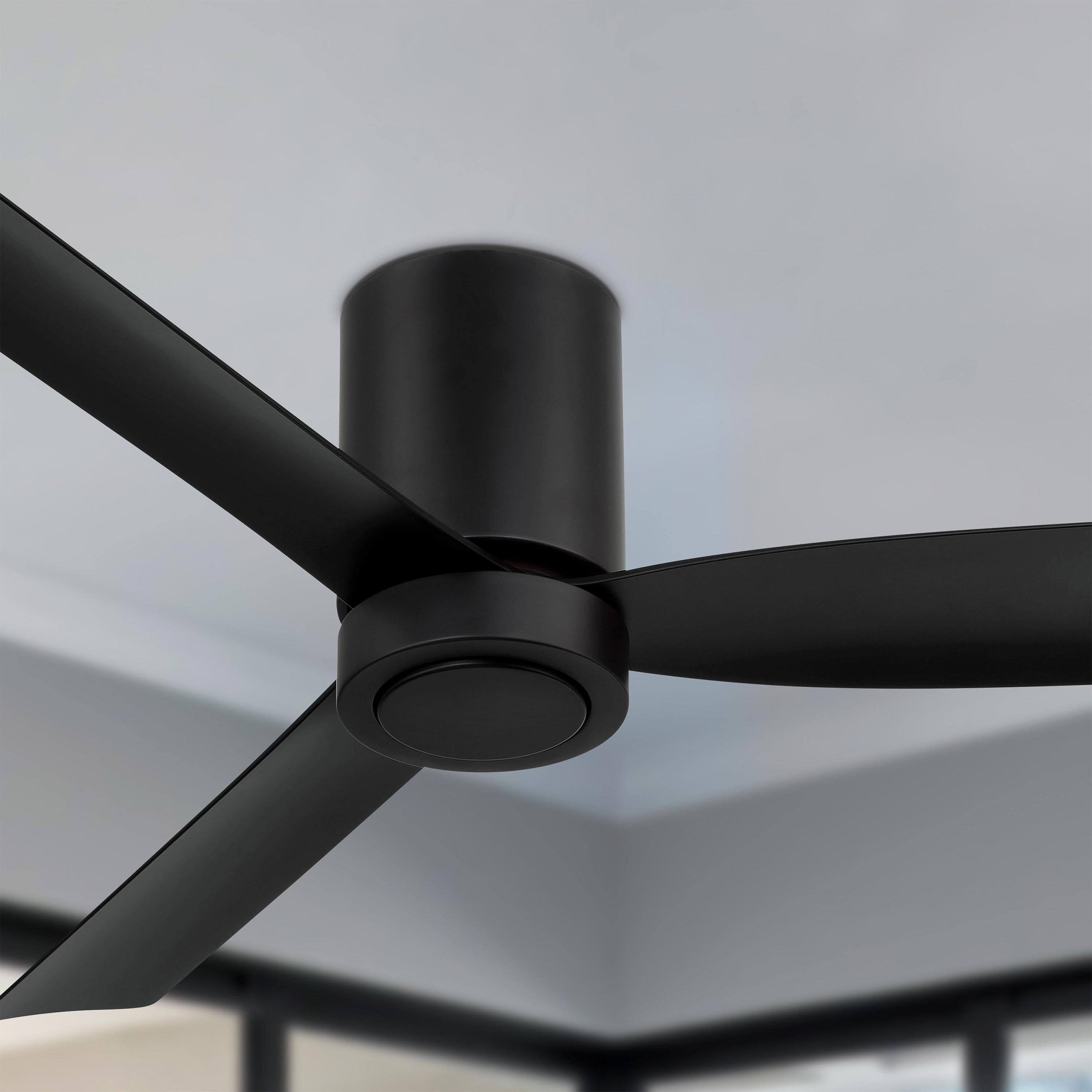 Black cormac 52 inch 3- blade ceiling fan mounted on a ceiling with a blurred background