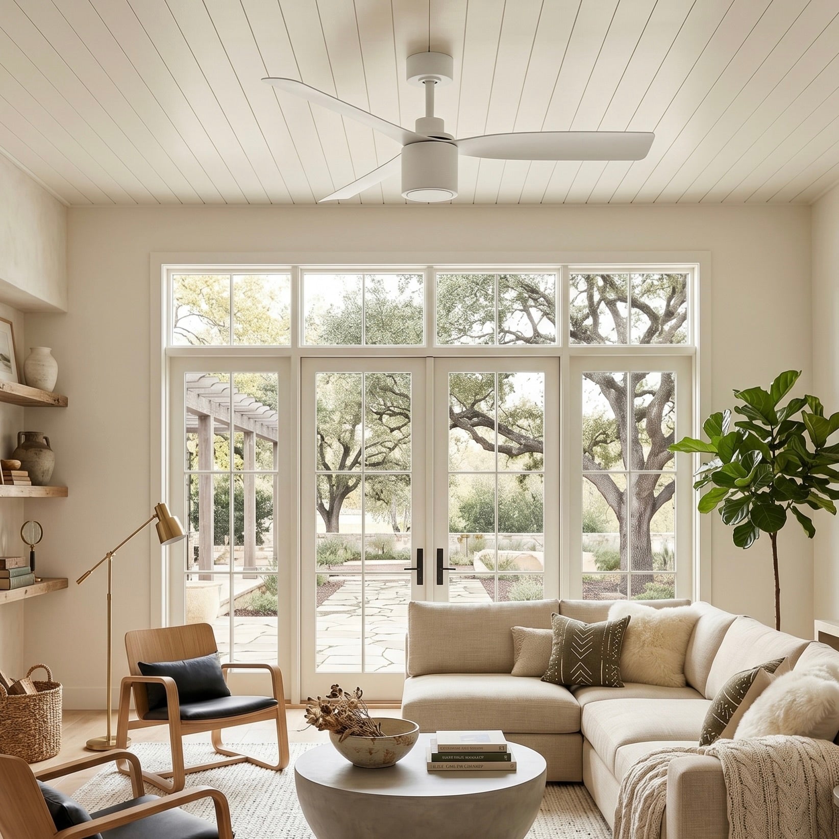Modern living room with white sectional sofa, armchair, coffee table, and large windows featuring the Ravian 3-blade ceiling fan with no light.
