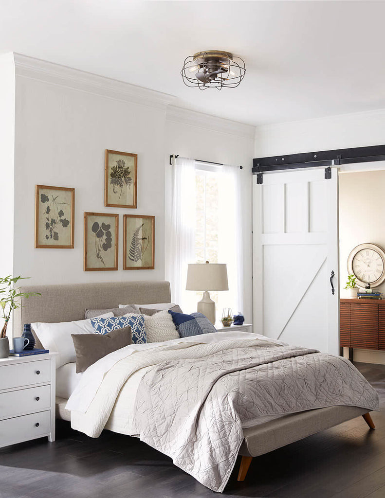 Flush Mount Ceiling Fan design with a Charred Iron Finish pictured above a bed in a contemporary style room. 