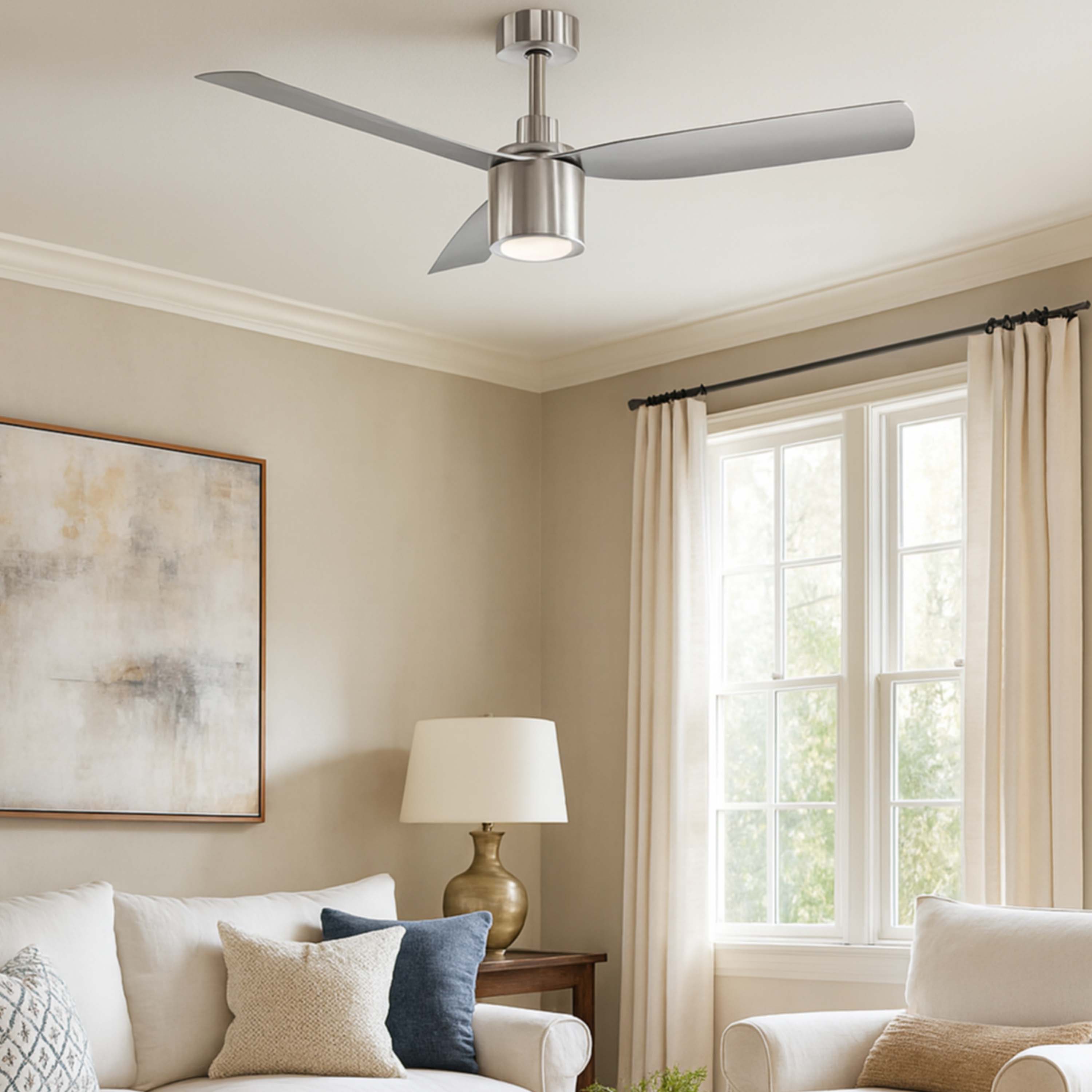 Living room with a ceiling fan, lamp, and window with curtains featuring the Ravian ceiling fan in brushed nickel with light. 