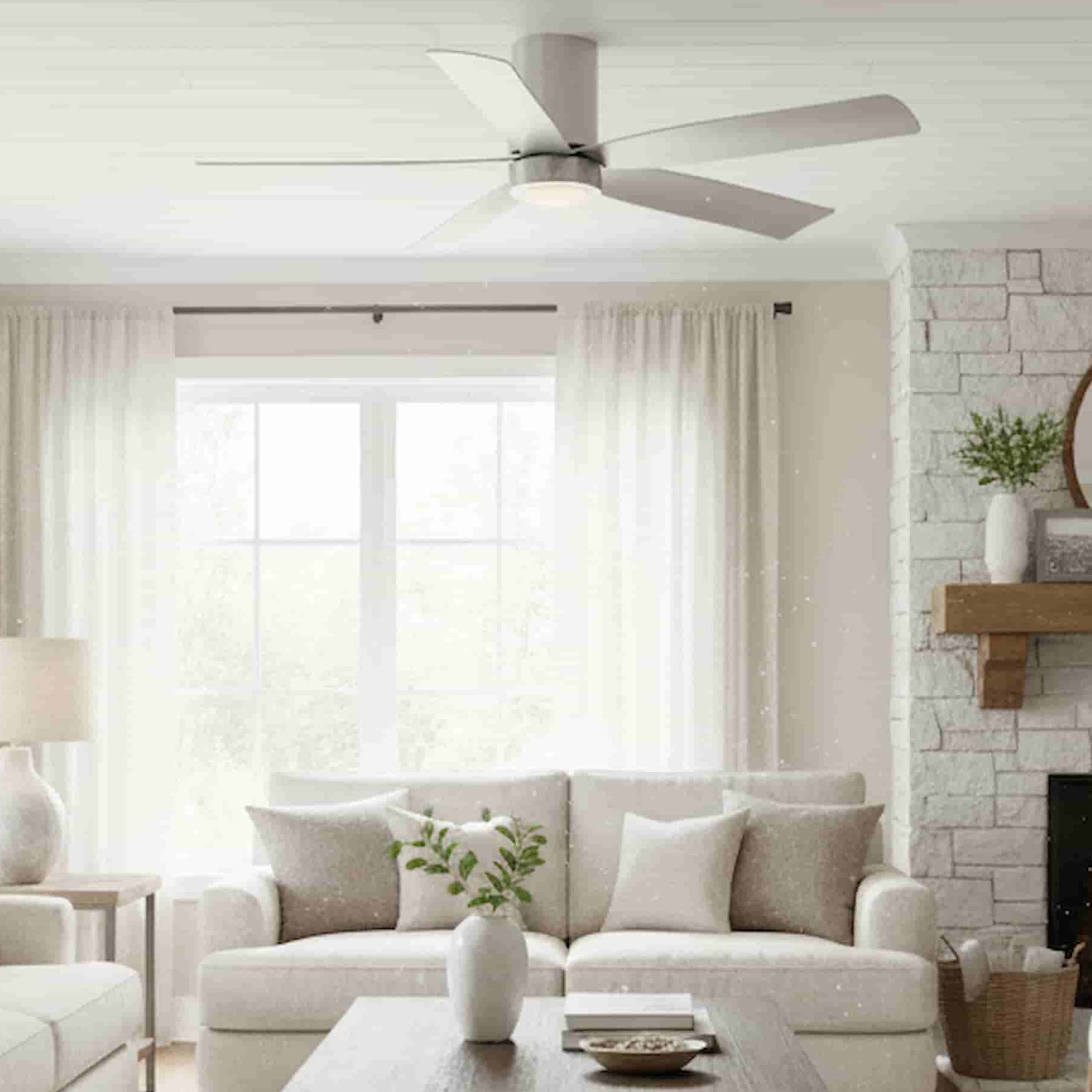 Living room with a cormac 5-blade brushed nickel ceiling fan, white sofa, and decorative elements.